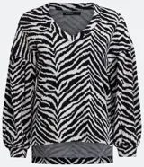 Blusa de viscosa con estampado animal print en blanco y negro, escote en V, mangas largas abullonadas con puños ajustados y dobladillo mullet.