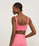 Top deportivo blanco de poliamida, sin copa, sin estampa y con escote redondo.