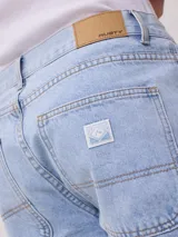 Bermuda de jean azul con bolsillos cargo laterales y corte a la rodilla.