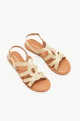 Sandalias bajas doradas con tiras finas cruzadas y hebilla en el tobillo.
