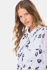 Blusa tipo camisa blanca de manga larga con botones nacarados ocultos.