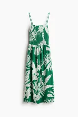 Vestido midi verde con estampado de hojas blancas, breteles finos y cuerpo superior fruncido con punto smock.