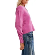 Buzo blanco de algodón con escote a la base, hombros caídos y mangas amplias con detalle de ojalillos y cordones en los puños.