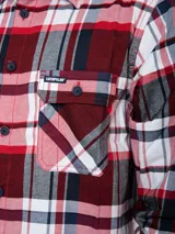 Camisa de manga larga con estampado a cuadros en tonos rojo, blanco, azul y gris. Tiene dos bolsillos en el pecho con cierre de botón, puños ajustables con botón y un paño de microfibra oculto en el dobladillo delantero.