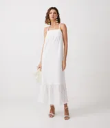 Vestido largo blanco de algodón con tirantes finos, escote cuadrado, detalles de laise en escote y ruedo, y lazo trenzado para atar en la cintura.