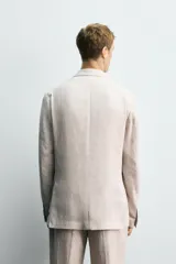 Blazer azul marino de lino, corte regular fit, con solapas de muesca, cierre de dos botones, bolsillo de vivo en el pecho, bolsillos de solapa en la cadera, aberturas en la espalda y puños con botones.