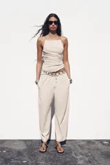 Pantalón ancho color beige, de tiro medio y cintura ajustable con cordones.