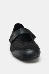 Zapato tipo bailarina color negro, con capellada de rejilla y ajuste con tira de velcro.