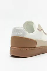 Zapatillas urbanas de gamuza color beige, blanco y verde, con recortes en símil cuero y suela de goma marrón de 2,5 cm de altura.
