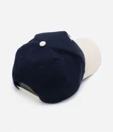 Gorra de sarga azul marino con visera curva color beige, bordado frontal con las letras LA en blanco y cierre ajustable en la parte posterior.