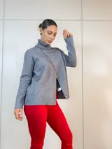 Sweater gris con cuello alto y corte asimétrico.