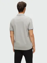 Remera polo gris de algodón de la marca Hugo Boss, corte regular fit, con cuello y mangas con ribete doble en blanco y negro, y logo bordado en el pecho.