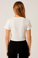 Remera corta negra con cuello redondo y apliques de strass en la parte superior.