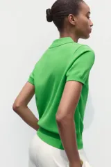 Top azul eléctrico de punto, con cuello polo, manga corta y cierre frontal con botones negros.