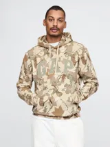 Canguro con capucha y cordones ajustables, color beige con estampado de hojas y logo GAP en el frente.
