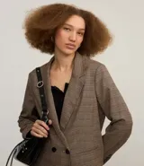 Blazer marrón con estampado de cuadros, corte oversized, cuello en V, manga larga y cierre con dos botones delanteros.