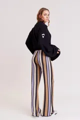Pantalón de punto con estampado geométrico en tonos lila, verde y beige.