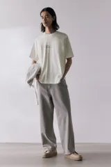 Remera blanca de corte holgado con estampado de texto en cursiva color negro en el centro del pecho.