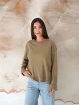 Remera de manga larga color verde oliva con cuello redondo y puños con dobladillo.