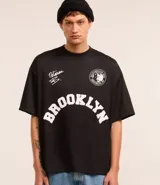 Remera negra de poliéster con corte oversized, cuello redondo, manga corta y estampa frontal con lettering y logo de Notorius BIG.