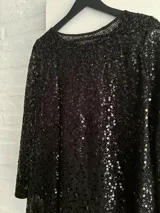 Minivestido negro con lentejuelas, de manga larga y escote redondo.