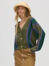 Cardigan corto de punto color verde oliva con rayas verticales en verde oscuro y lila. Tiene escote en V, mangas largas y botones al frente.