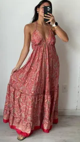 Vestido largo de seda con estampado de cachemir en tonos rojos y amarillos, con escote halter y falda escalonada con volantes.