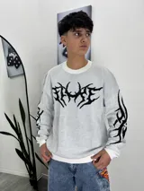 Sweater de punto color gris claro con cuello, puños y ruedo acanalados en blanco. Presenta un estampado abstracto en negro en el frente y en las mangas. Corte boxy fit.
