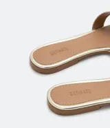 Sandalia plana de cuero sintético color negro, con puntera cuadrada y tiras anchas cruzadas en el empeine.