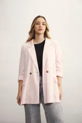 Blazer celeste de lino con solapas de muesca, cierre cruzado con botones, bolsillos delanteros con solapa y corte holgado.