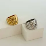 Anillo dorado con diseño texturizado en forma de croissant, fabricado en acero quirúrgico hipoalergénico con baño de oro de 18K.