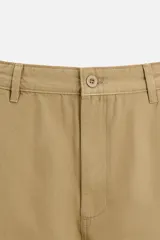 Pantalón chino color beige de corte recto, con cintura ajustable con cordón interior y trabillas laterales. Tiene bolsillos frontales y traseros de vivo.