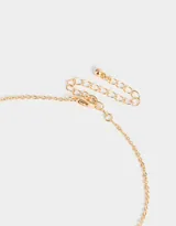 Collar corto dorado con cadena de eslabones y dijes de flores esmaltadas negras.
