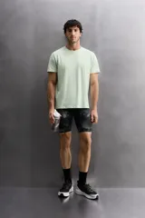Mallas deportivas cortas de tejido técnico elástico con estampado abstracto en tonos grises.