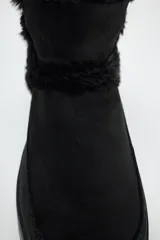 Botín negro de caña baja con interior de efecto pelo y suela tipo flatforma.