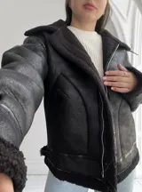 Campera oversize color negro, con detalle de pelo en el interior y exterior, diseño de cierre frontal.