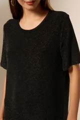 Vestido negro corto de manga corta, holgado y con cuello a la base.