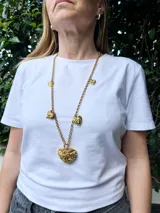 Collar largo dorado con cadena de eslabones y dijes de corazones texturizados.