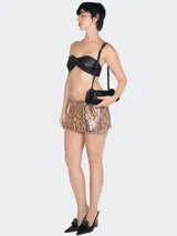 Minifalda con estampado de piel de serpiente y hebilla con pedrería.
