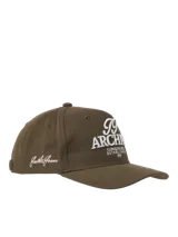 Gorra marrón de cinco paneles con bordado frontal con la inscripción "TT Archive Club Creative Dept. Established 1990".