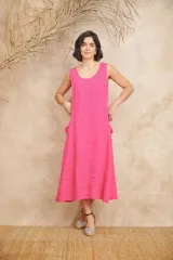 Vestido midi color beige de lino, corte amplio, sin mangas y con bolsillos laterales.