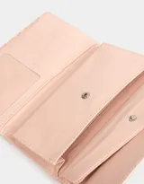 Billetera color rosa pálido con estampado de flores pequeñas, formato fichero con solapa y tag en relieve. Tiene cierre superior con puller, solapa con broche, compartimento para tarjetas y bolsillo interno con solapa.
