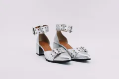 Zapato plateado de cuero con taco cuadrado, punta fina y pulsera con hebilla y ojales.