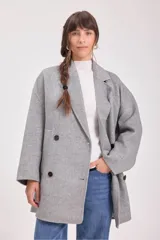 Tapado gris de lana con doble botonadura, cuello con solapas y bolsillos laterales.