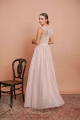 Vestido largo de fiesta color rosado con lunares blancos. Tiene cuerpo de micro tul bordado con volados en los hombros y falda de tul con forro. Incluye cinturón de raso al tono.