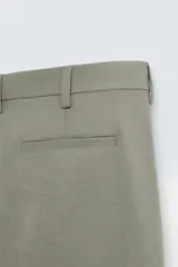 Pantalón chino de vestir negro, corte slim fit, con bolsillos laterales y traseros. Cierre frontal con cremallera y botón.