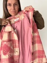 Campera oversize de paño con diseño cuadrillé en tonos rosa y crudo, corte recto y amplio, con botones frontales, bolsillos laterales y forro interior.