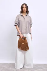 Camisa marrón a rayas verticales blancas y marrones, de corte amplio y mangas cortas.