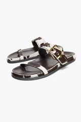 Sandalias planas con estampado animal print de piel con pelo, cierre mediante hebilla metalizada y punta redonda.