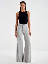 Pantalón de denim gris claro, de corte acampanado, con cierre y botón. Tiene dos bolsillos delanteros y dos traseros.